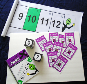 Learning material bundle for the times tables. Includes a workbook, a vinyl mat 2 m. long by 40 cm wide, 2 cardboard dice 10 cm by side and 9 bingo cards.